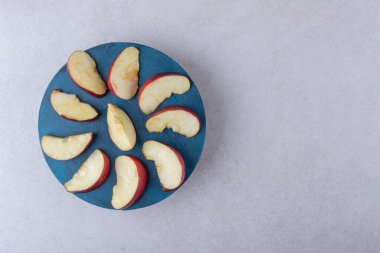 Elma dilimleri bir tabakta, mermer zemin üzerinde. Yüksek kalite fotoğraf