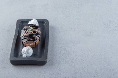 Siyah tabağa serpiştirilmiş mini, lezzetli çikolatalı pasta. Yüksek kalite fotoğraf