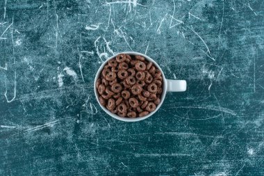 Mavi arka planda bir fincan mısır halkası. Yüksek kalite fotoğraf