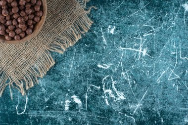 Mavi arka planda, havlunun üzerindeki bir kasede mısır topları. Yüksek kalite fotoğraf