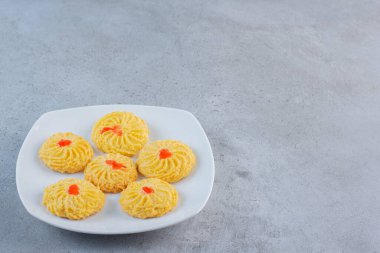 Taş zeminde beyaz bir tabak lezzetli yuvarlak bisküvi. Yüksek kalite fotoğraf