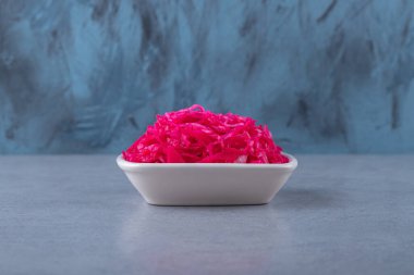 Mayalanmış kırmızı lahana mermer arka planda, kâsede yatıyor. Yüksek kalite fotoğraf