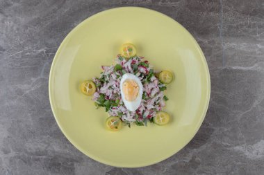 Haşlanmış yumurta, dilimlenmiş turp ve sarı tabakta yeşillikler. Yüksek kalite fotoğraf