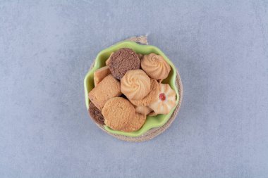 Çuval bezinde tatlı, yuvarlak, lezzetli kurabiyeler olan yeşil bir tabak. Yüksek kalite fotoğraf