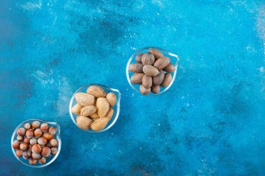 Mavi arka planda, kaselerin üzerinde fındık çeşitleri. Yüksek kalite fotoğraf