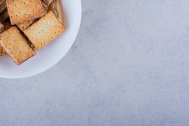 Taş zeminde beyaz bir tabak lezzetli çıtır kraker. Yüksek kalite fotoğraf