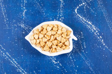 Yaprak şeklinde tabağa konmuş tuzlu kalp şeklinde kraker yığını. Yüksek kalite fotoğraf