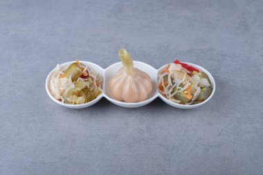 Lahana turşusu ve sarımsak bir kasede, mermer arka planda. Yüksek kalite fotoğraf