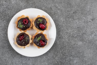 Gri arka planda beyaz tabakta ev yapımı taze çikolatalı kurabiyelerin üst görüntüsü. Yüksek kalite fotoğraf
