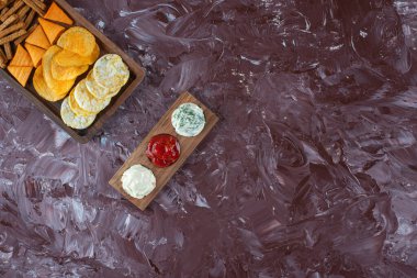 Mermer zemin üzerinde soslu çeşitli cipsler var. Yüksek kalite fotoğraf