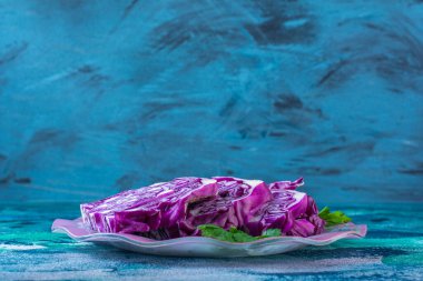 Mavi arka planda kırmızı lahana ve maydanoz tabakta. Yüksek kalite fotoğraf