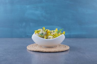 Gri arka planda beyaz kasede kurutulmuş sağlıklı bitkiler. Yüksek kalite fotoğraf