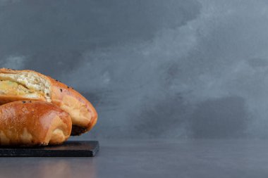 Siyah tahtada susam tohumlu yarı kesilmiş taze hamur işleri. Yüksek kalite fotoğraf