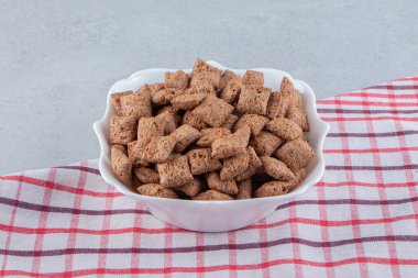 Çikolata pedleri taştan arka planda beyaz kasede mısır gevreği. Yüksek kalite fotoğraf