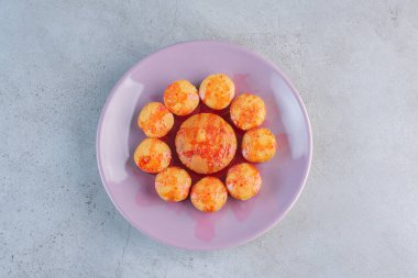 Arka planda çilek sosu olan mor bir tabak mini kek. Yüksek kalite fotoğraf