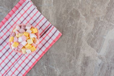 Pamuk peçetedeki kasede renkli yumuşak şekerler yığını. Yüksek kalite fotoğraf