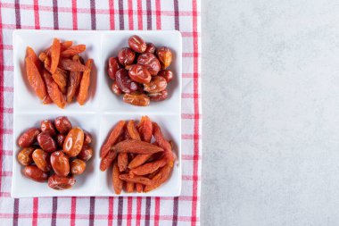Taş zeminde çeşitli lezzetli kurutulmuş meyveler olan beyaz tabak. Yüksek kalite fotoğraf