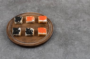 Tahta tahtada kırmızı ve siyah havyarlı küçük sandviçler. Yüksek kalite fotoğraf