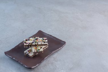 Koyu tabağa serpiştirilmiş çıtır vanilyalı waffle. Yüksek kalite fotoğraf