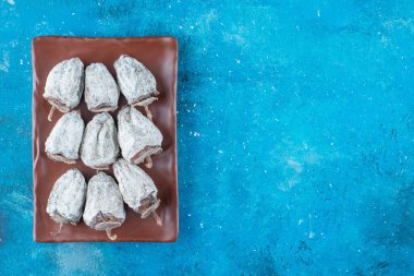 Mavi arka planda, tabakta kurutulmuş hurma. Yüksek kalite fotoğraf