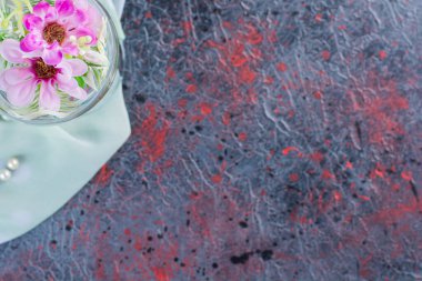 Masa örtüsü üzerinde çiçekler olan cam vazonun üst görüntüsü. Yüksek kalite fotoğraf