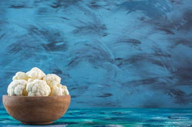 Mavi arka planda bir kase taze karnabahar. Yüksek kalite fotoğraf