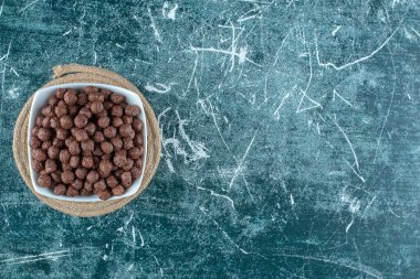 Mavi arka planda, bir kasede mısır gevreği. Yüksek kalite fotoğraf