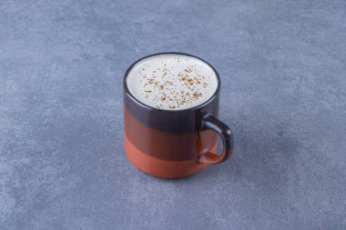 Mavi arka planda bir bardak sütlü kapuçino. Yüksek kalite fotoğraf