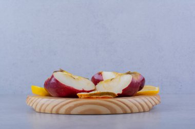 Tahta bir tabak taze elma ve arka planda limon dilimleri. Yüksek kalite fotoğraf