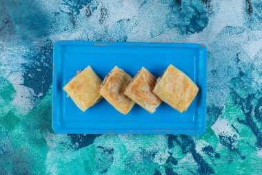 Tahta tepside dilimlenmiş sığır eti dolması, mermer arka planda. Yüksek kalite fotoğraf