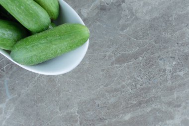 Gri arka planda beyaz kâse içinde taze yeşil salatalık manzarası. Yüksek kalite fotoğraf