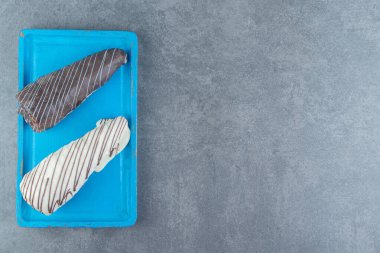 Mavi tabakta kremayla dolu iki tüp şeklinde hamur işi. Yüksek kalite fotoğraf