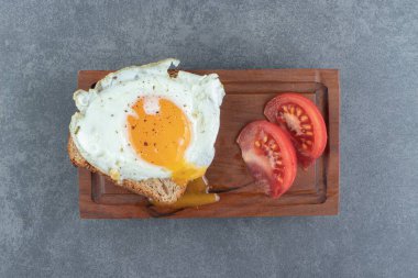 Tahtada kızarmış yumurta ve domatesli tost ekmeği. Yüksek kalite fotoğraf
