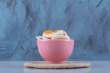 Gri arka planda yağda kızartılmış yumurtalı pembe bir kase. Yüksek kalite fotoğraf