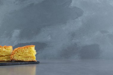 Karanlık tahtada dilimlenmiş taze hamur işi. Yüksek kalite fotoğraf