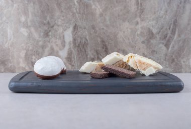 Yuvarlak kek, jöleli bisküvi ve çikolatalı gofret tahta tepside, mermer arka planda. Yüksek kalite fotoğraf