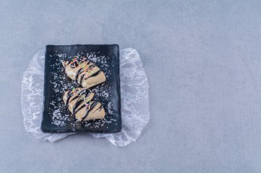 Çikolata soslu siyah bir tabak hamur işi. Yüksek kalite fotoğraf