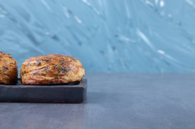 Çıtır çıtır, katmanlı, tahta tabakta çikolatalı gogal, mermer arka planda. Yüksek kalite fotoğraf