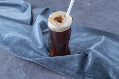 Mavi arka planda, kumaş parçasında köpüklü nitro kahve. Yüksek kalite fotoğraf