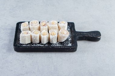 Taş zeminde fındık olan lezzetli ikramlardan oluşan siyah kesim tahtası. Yüksek kalite fotoğraf