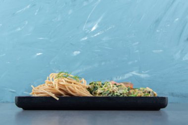 Sebzeli omlet ve siyah tabakta spagetti. Yüksek kalite fotoğraf