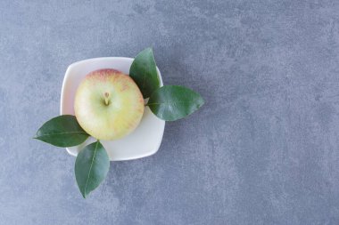 Arkaplanda yaprakları olan tek bir elma. Yüksek kalite fotoğraf