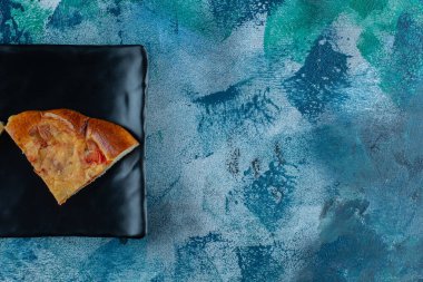 Siyah tabakta, mermer arka planda nefis bir mini pizza. Yüksek kalite fotoğraf