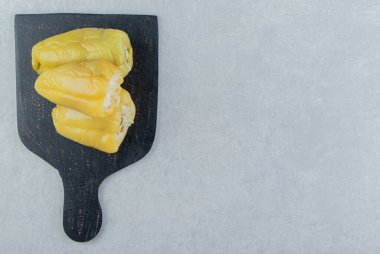 Kesme tahtasına lahana turşusuyla doldurulmuş biberler, mermer arka planda. Yüksek kalite fotoğraf