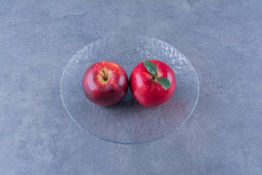 Cam tabakta, mermer zeminde dişli elmalar. Yüksek kalite fotoğraf