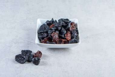 Taş zeminde beyaz bir kase kurutulmuş hurma. Yüksek kalite fotoğraf