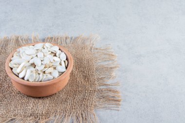 Taş zeminde seramik bir kap çiğ kabak çekirdeği. Yüksek kalite fotoğraf