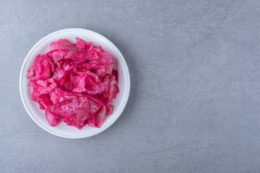 Mermer zemin üzerinde, tabakta mayalanmış kırmızı lahana parçası. Yüksek kalite fotoğraf