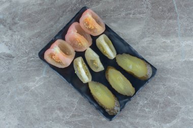 Ev yapımı turşu dilimleri. Siyah tabakta domates ve salatalık dilimleri. Yüksek kalite fotoğraf