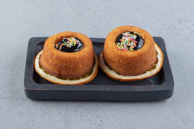 Portakal diliminin üzerine jöle konmuş iki mini kek tabağı. Yüksek kalite fotoğraf